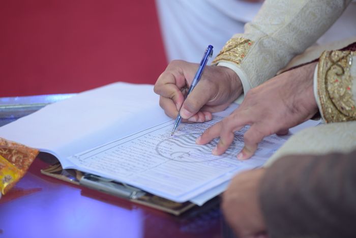 Groom signing the marriage contract at a Nikah
